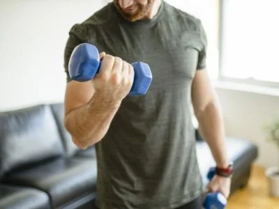 un hombre haciendo un ejercicio de biceps en su casa