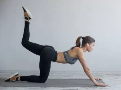 mujer haciendo un ejercicio de gluteos en el suelo